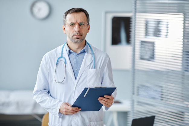 Horizontal medium portrait of serious mature caucasian medical specialist wearing lab coat and steth