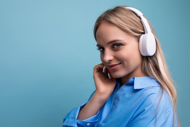 Horizontal photo of an attractive girl in wireless large headphones listening with pleasure to music