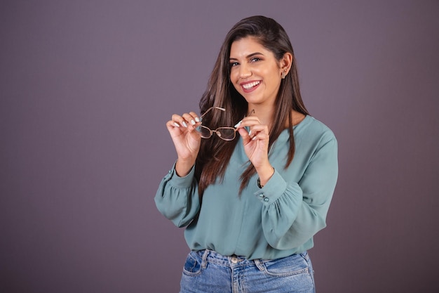 Horizontal photo Beautiful Brazilian woman with casual clothes Jeans and green shirt holding glasses