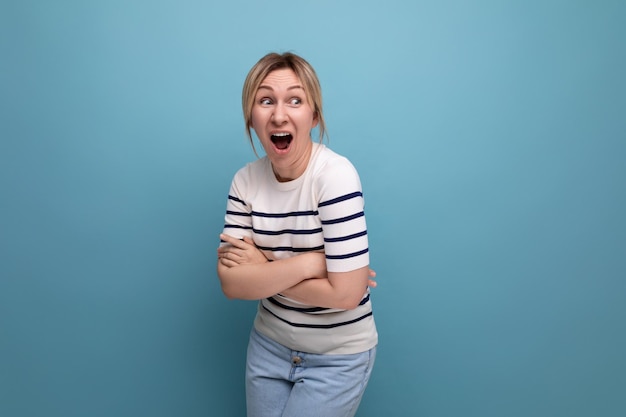 Horizontal photo of bright cheerful happy blonde woman in casual outfit on blue background with copy