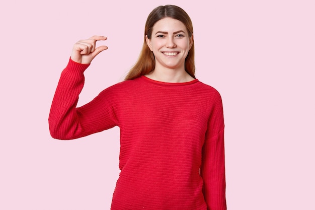 Horizontal shot of attractive young woman shows tiny object