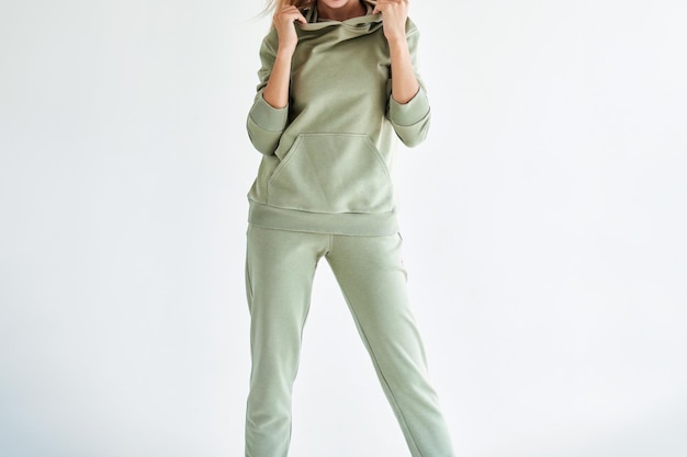 Photo horizontal studio photo for sports clothing sale model showcasing a stylish and comfortable outfit perfect for everyday wear a girl wears a light green hoodie and pants