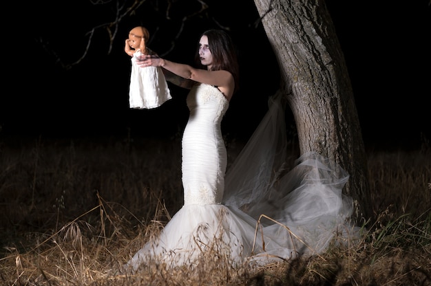 Horror Scene of a Woman Possessed holding a doll