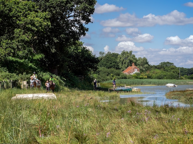 Photo horse riding and walking the dog by the river alde