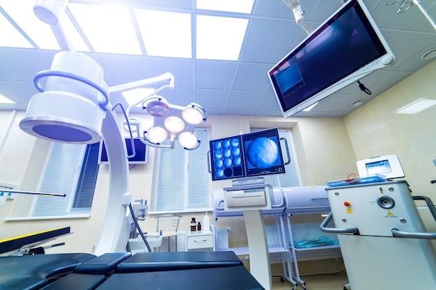 Hospital interior with operating surgery table lamps and ultra modern devices technology in modern clinic