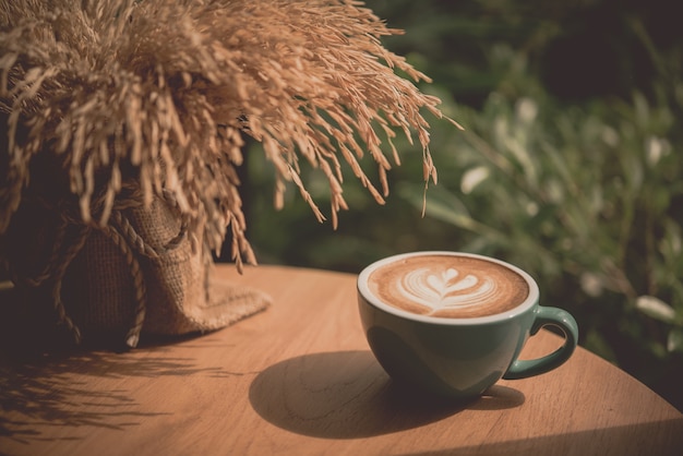 Hot art Latte Coffee in a cup on wooden table and morning light