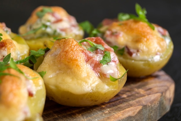 Hot baked stuffed potatoes with cheese, bacon, parsley on a wooden Board.