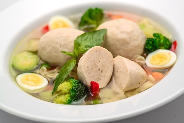 Hot chicken soup, broth with meatballs, carrot, pasta and fresh parsley