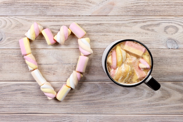 Photo hot chocolate with heart shape marshmallow. warm cocoa with marshmallows. cup of hot cocoa with marshmallows on the wooden table