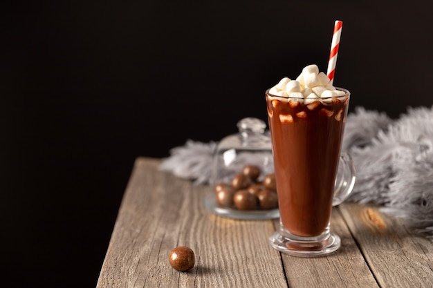 Hot chocolate with marshmallow on wooden table with copy space