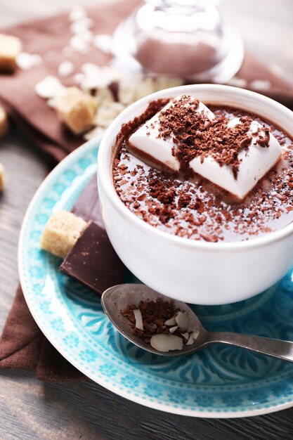 Hot chocolate with marshmallows in mug on color wooden background