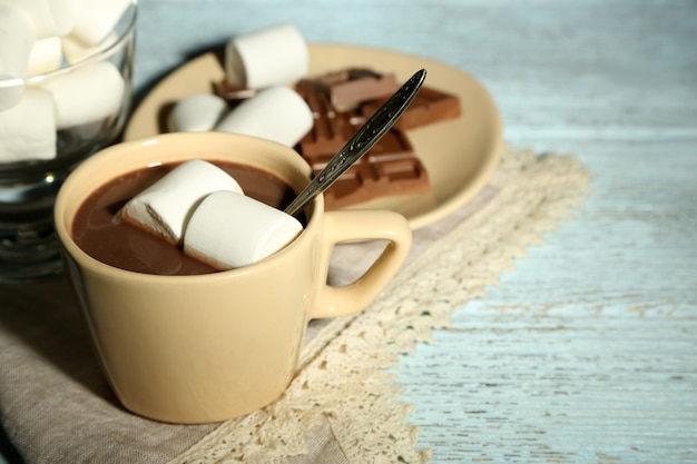 Photo hot chocolate with marshmallows in mug, on wooden background