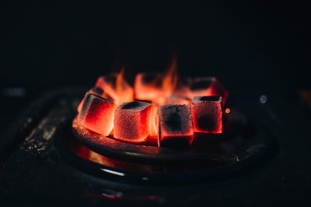 Hot coals for Shisha warmed up on the stove in a hookah bar