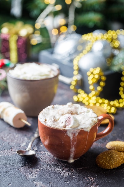 Hot cocoa with marshmallows, cream and cookies on holiday christmas background