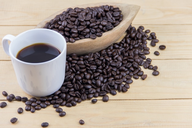 Hot coffee and coffee bean on desk