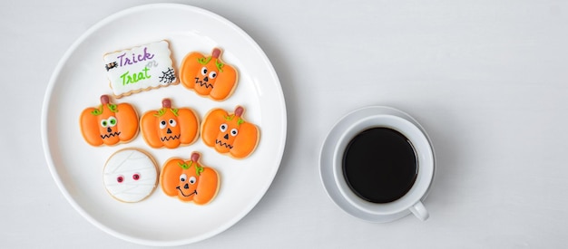 Hot coffee cup with funny Halloween Cookies Happy Halloween day Trick or Threat Hello October fall autumn Traditional party and holiday concept