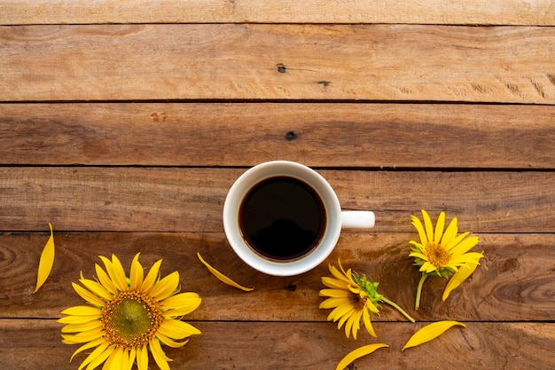 hot coffee espresso with flowers sunflowers arrangement on wooden