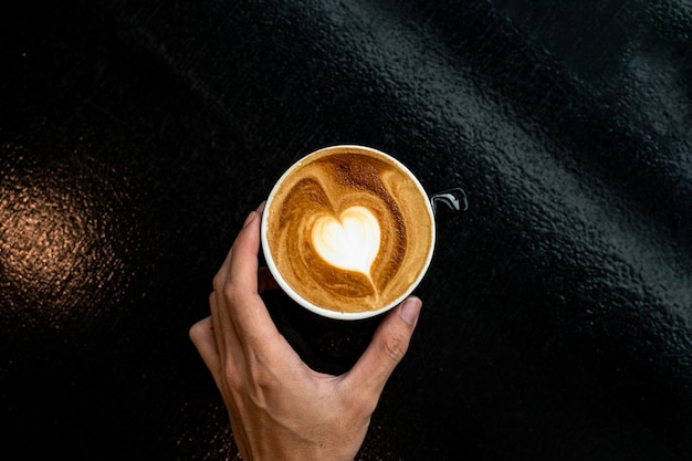 hot coffee latte art heart shape on black table