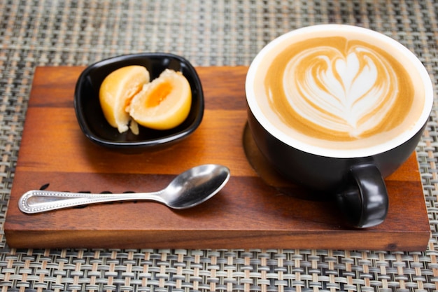 Hot coffee latte art serve with chinese pastry moon cake serve on wooden tray for travelers thai people rest relax eat and drinks at cafe restaurant shop in Bangkok Thailand