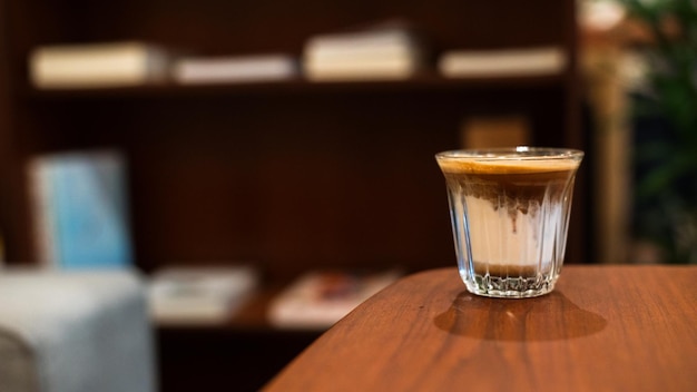 Hot coffee on a table with cream being poured into it showing the texture