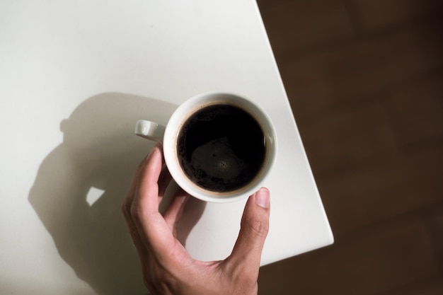 hot coffee on a table with cream being poured into it showing the texture