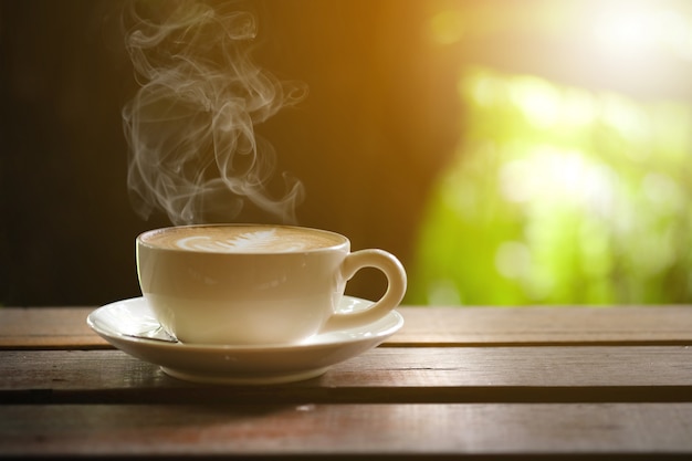 Hot coffee on wooden table on the terrace.