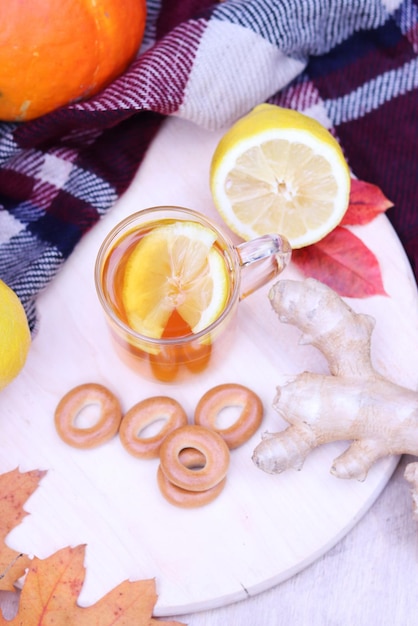 Hot cup of tea with autumn leaves, pumpkins, ginger, lemon and bagels. Autumn mood. Warming drink