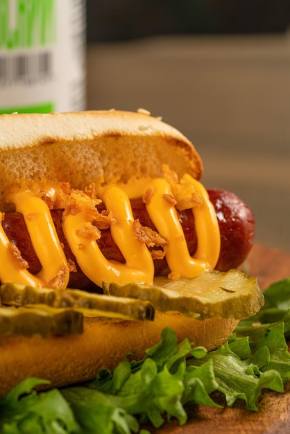 Hot dog on a dark wooden background fried sausage in sauce