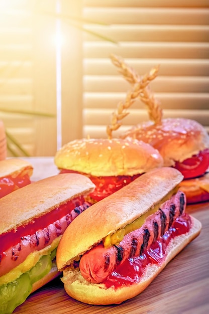 Hot dogs on wooden board in sunny cafe