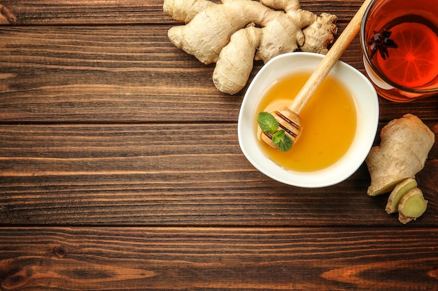 Hot drink with honey lemon and ginger for cough remedy on wooden table