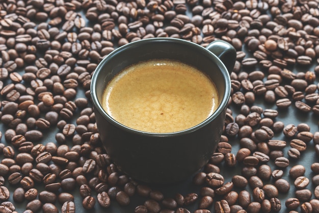 Hot espresso and coffee bean on black table 