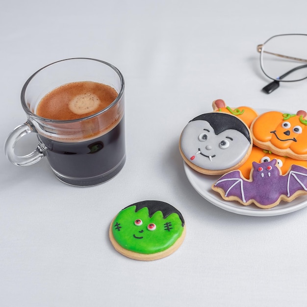 Hot espresso coffee or chocolate cup with funny Halloween Cookies Happy Halloween day Trick or Threat Hello October fall autumn Traditional party and holiday concept