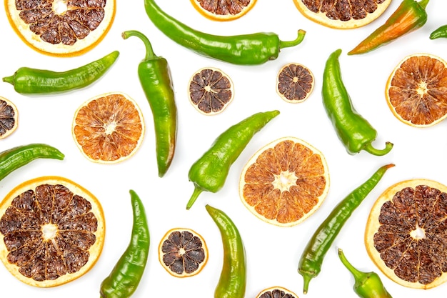 Hot green peppers and dried citrus fruit on a white background grocery organic flatley