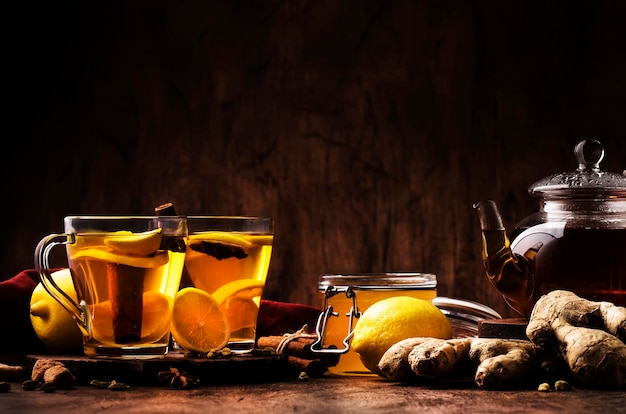 Hot healing tea with ginger honey lemon and spices in glass cup rustic wooden background copy space