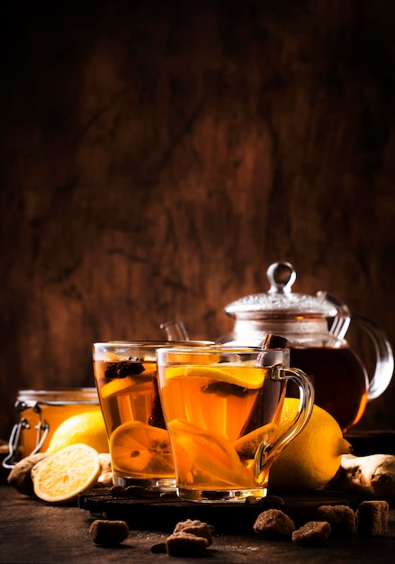 Hot healing tea with ginger honey lemon and spices in glass cup rustic wooden background copy space.