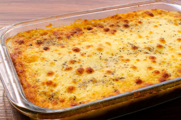 Hot lasagna on wooden table Meat Lasagna or Chicken Lasagna baked in an oven with melted cheese.