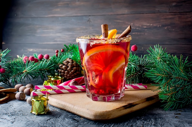 Hot mulled wine drink with orange, and christmas decorations