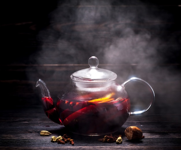 Hot mulled wine in a transparent glass teapot