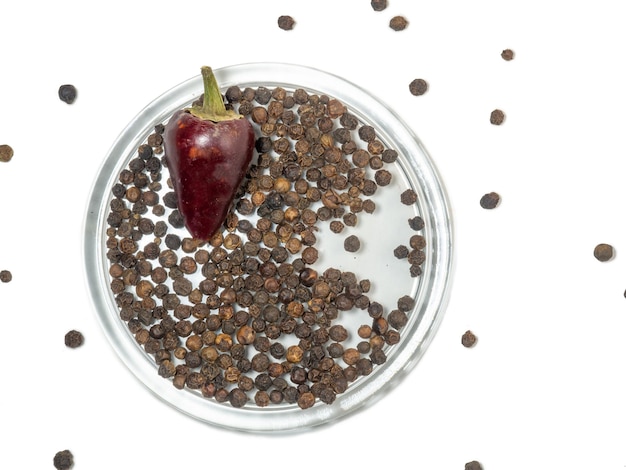 Hot pepper and black peppercorns on a white background