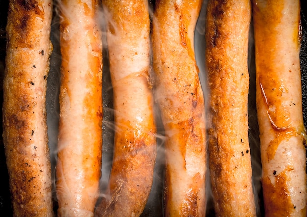 Hot sausages in a frying pan. Top view