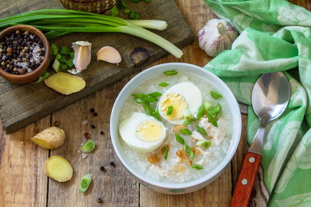 Hot soup chicken with ginger rice and garlic in a bowl on a rustic table