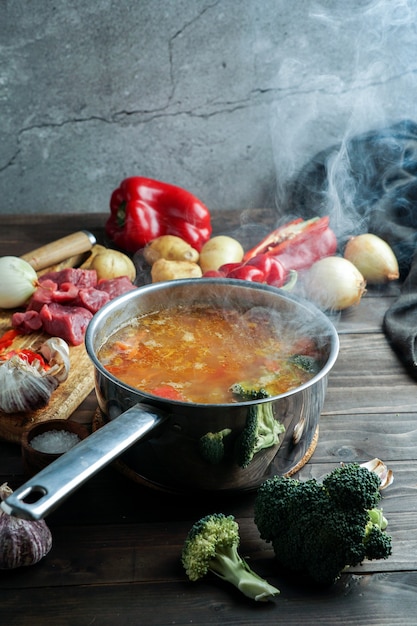 Hot soup in a saucepan is steaming. with beef and vegetables. hearty, nutritious dish. dinner