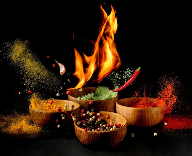 Hot Spices and seasonings powder splash explosion on black background with flame