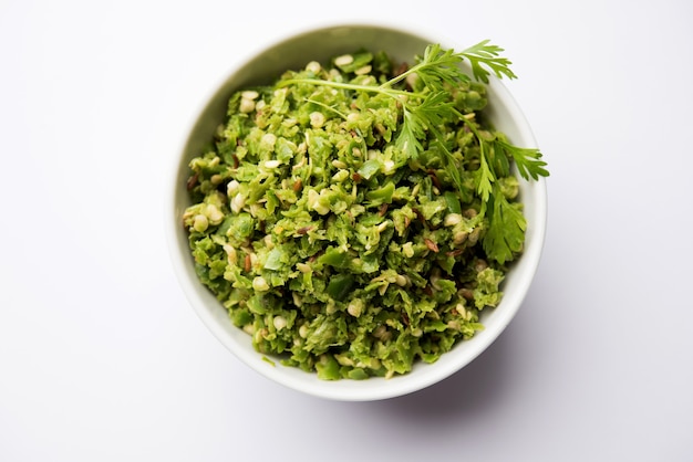 Hot and spicy green chilli chutney using hari mirch, cumin seeds, lemon juice and coriander. served in a bowl. selective focus