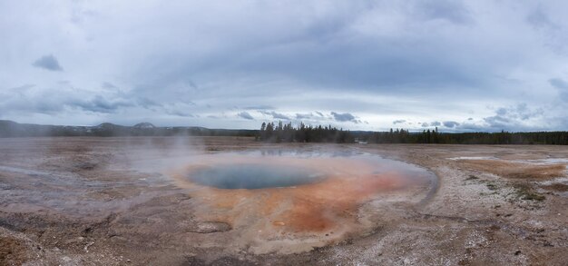 Hot spring geyser with colorful water in american landscape