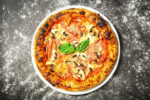 Hot tasty traditional pizza with ham and mushrooms