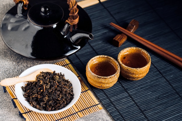 Hot tea in glass teapot and cup with steam