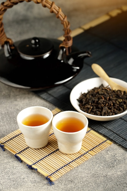 Hot tea in glass teapot and cup with steam