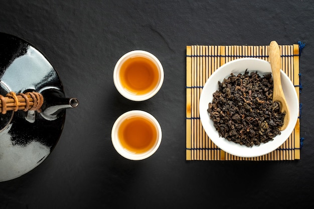 Hot tea in glass teapot and cup with steam