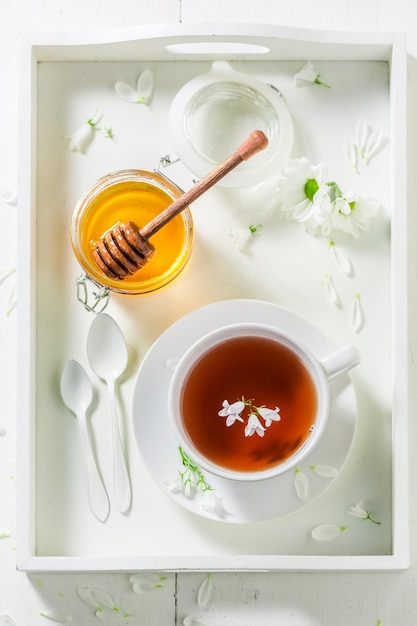 Hot tea with honey in sunny summer day